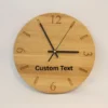 Handmade oak clock engraved with numbers 12, 3, 6, and 9, with line markers for other hours. Shown with black clock hands.