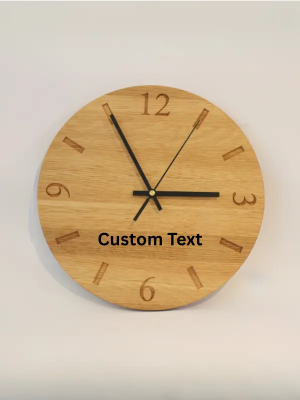 Handmade oak clock engraved with numbers 12, 3, 6, and 9, with line markers for other hours. Shown with black clock hands.