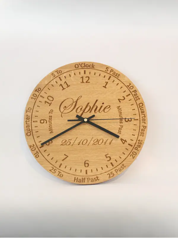 Handmade oak learning clock with engraved numbers, shown with black clock hands. A personalised wooden wall clock ideal for teaching children to tell the time.