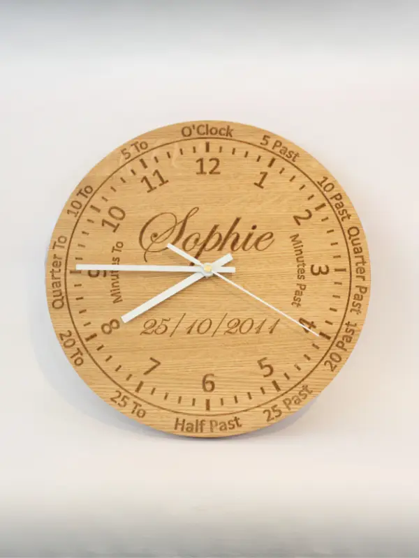 Handmade oak learning clock with engraved numbers, shown with black clock hands. A personalised wooden wall clock ideal for teaching children to tell the time.