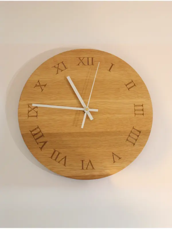 Handmade oak clock engraved with Roman numerals I to XII, A personalised wooden wall clock with optional engraving for names, dates, messages, or logos.