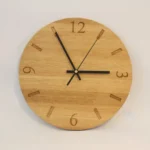 Handmade oak clock engraved with numbers 12, 3, 6, and 9, with line markers for other hours. Shown with black clock hands.