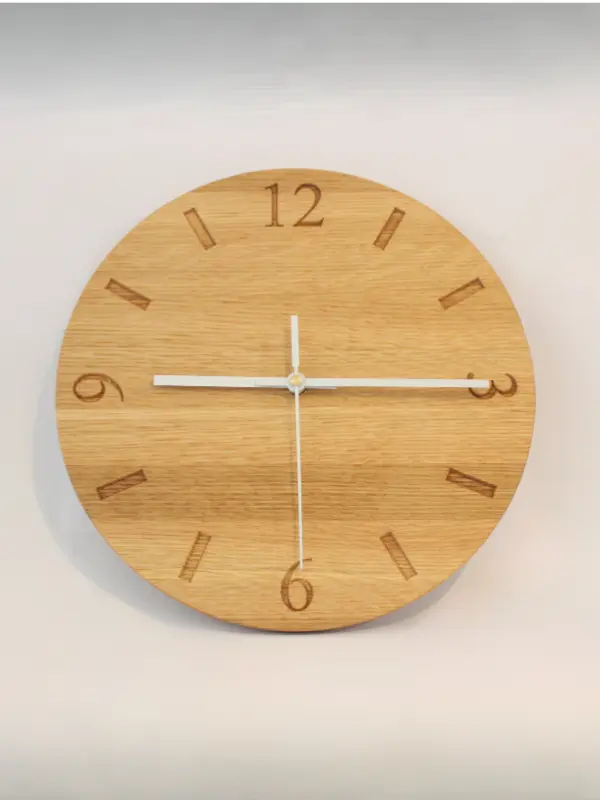 Handmade oak clock engraved with numbers 12, 3, 6, and 9, with line markers for other hours. Shown with white clock hands.